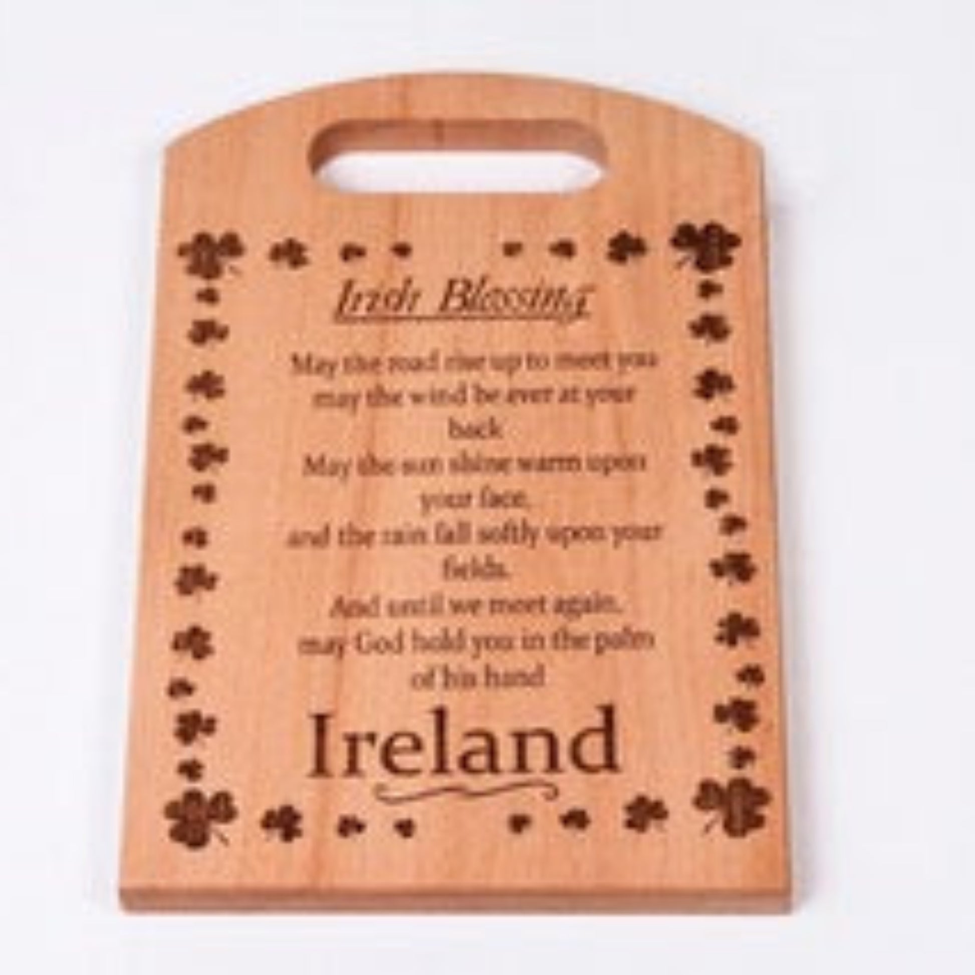 Wooden cutting board with engraved text and clover designs on a white background