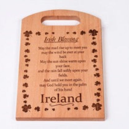 Wooden cutting board with engraved text and clover designs on a white background