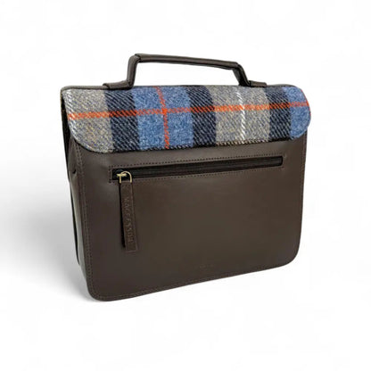 Brown leather bag with plaid fabric flap on a white background