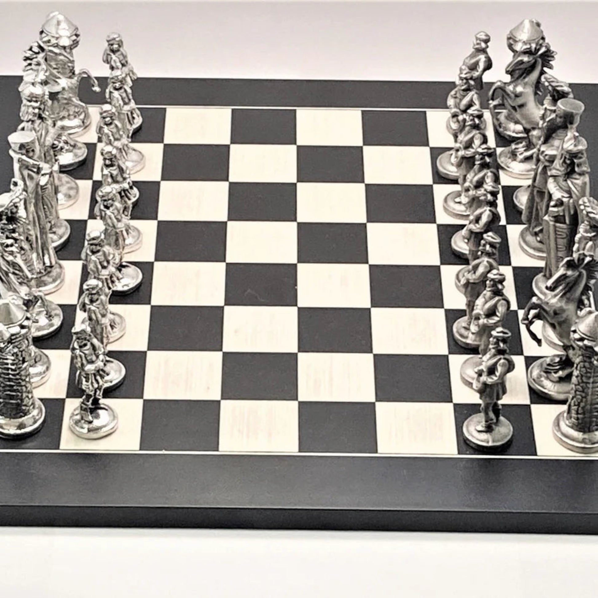 Silver chess pieces on a black and white checkered chessboard