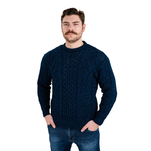 Man wearing a dark blue cable knit sweater on a white background