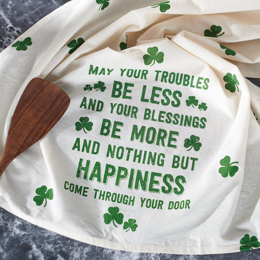 White towel with green text and shamrock patterns on a marble surface