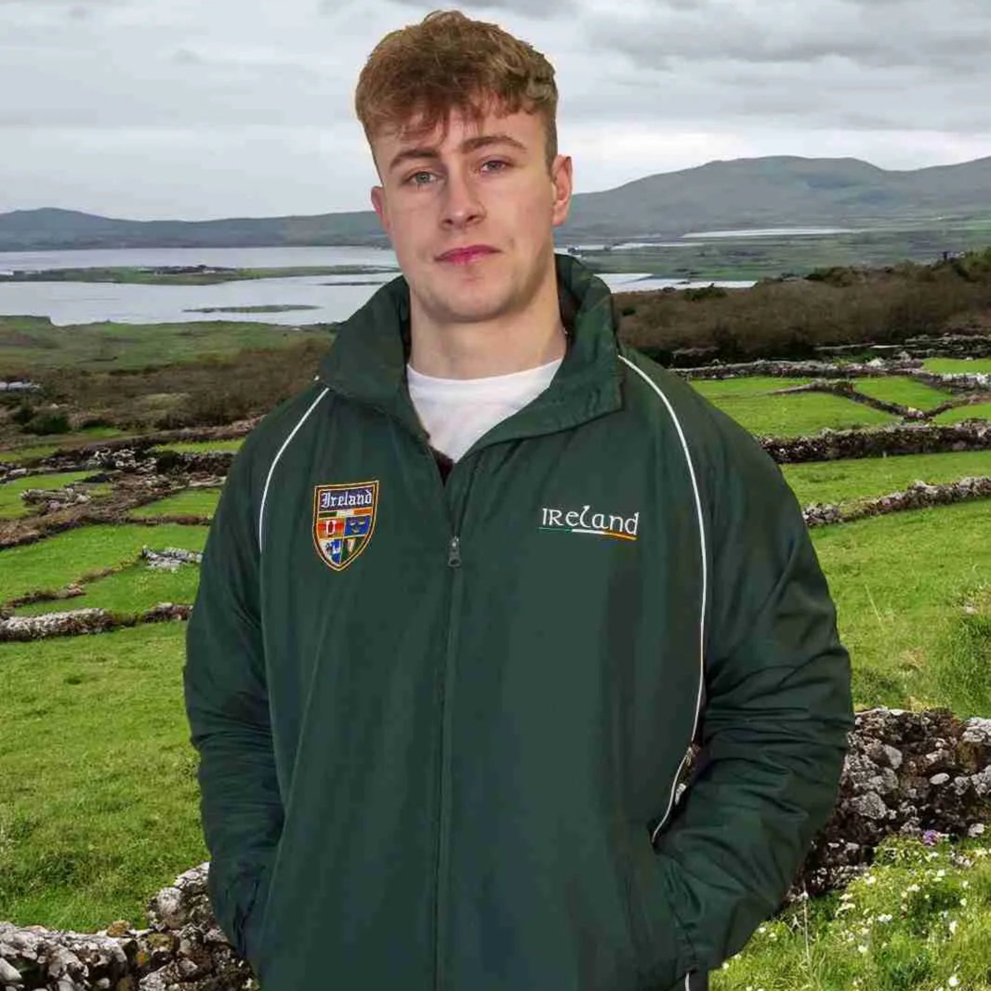 Person wearing a green jacket with 'Ireland' branding in a scenic outdoor setting.