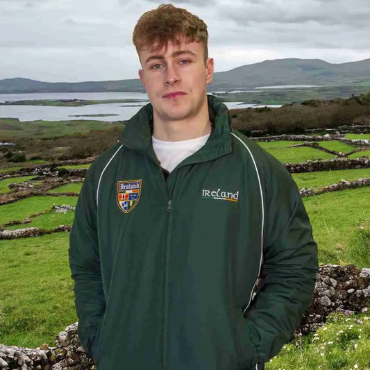 Person wearing a green jacket with 'Ireland' branding in a scenic outdoor setting.