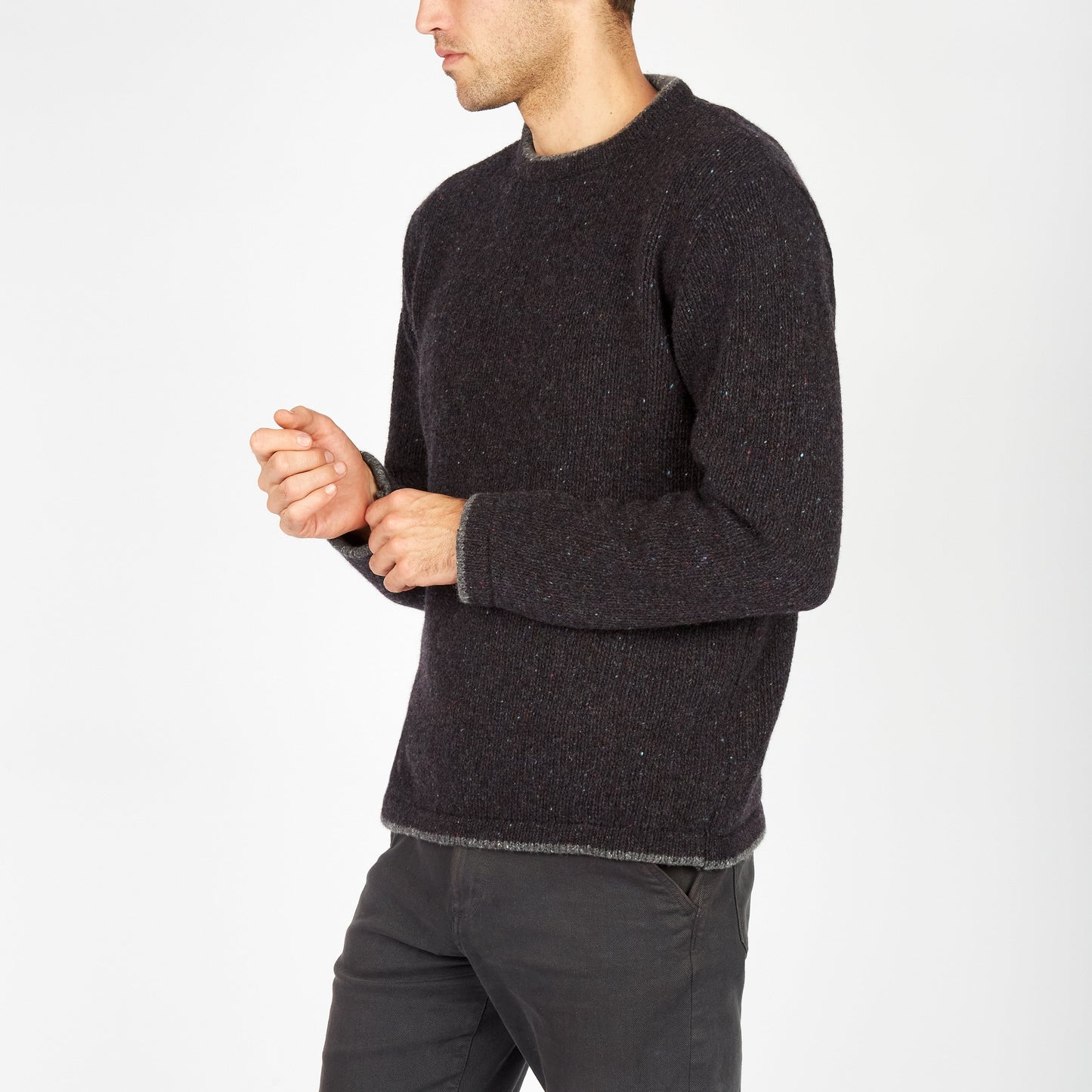 Man wearing a dark gray sweater and pants on a white background