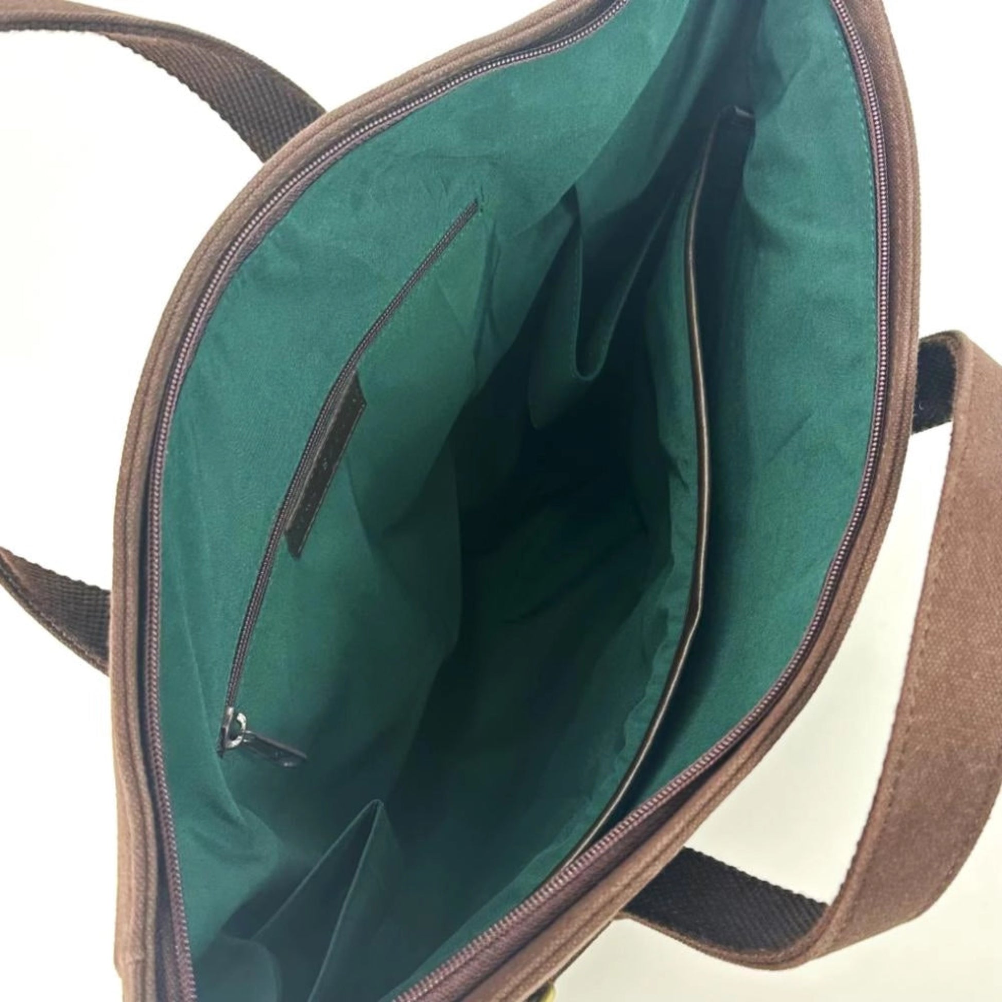 Open green bag with brown straps on a white background