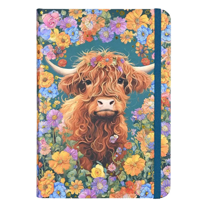 Blue notebook covered in flower designs with a highland cow in the center.