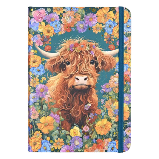 Blue notebook covered in flower designs with a highland cow in the center.
