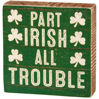 Decorative sign with shamrocks and text 'Part Irish All Trouble' on a green background