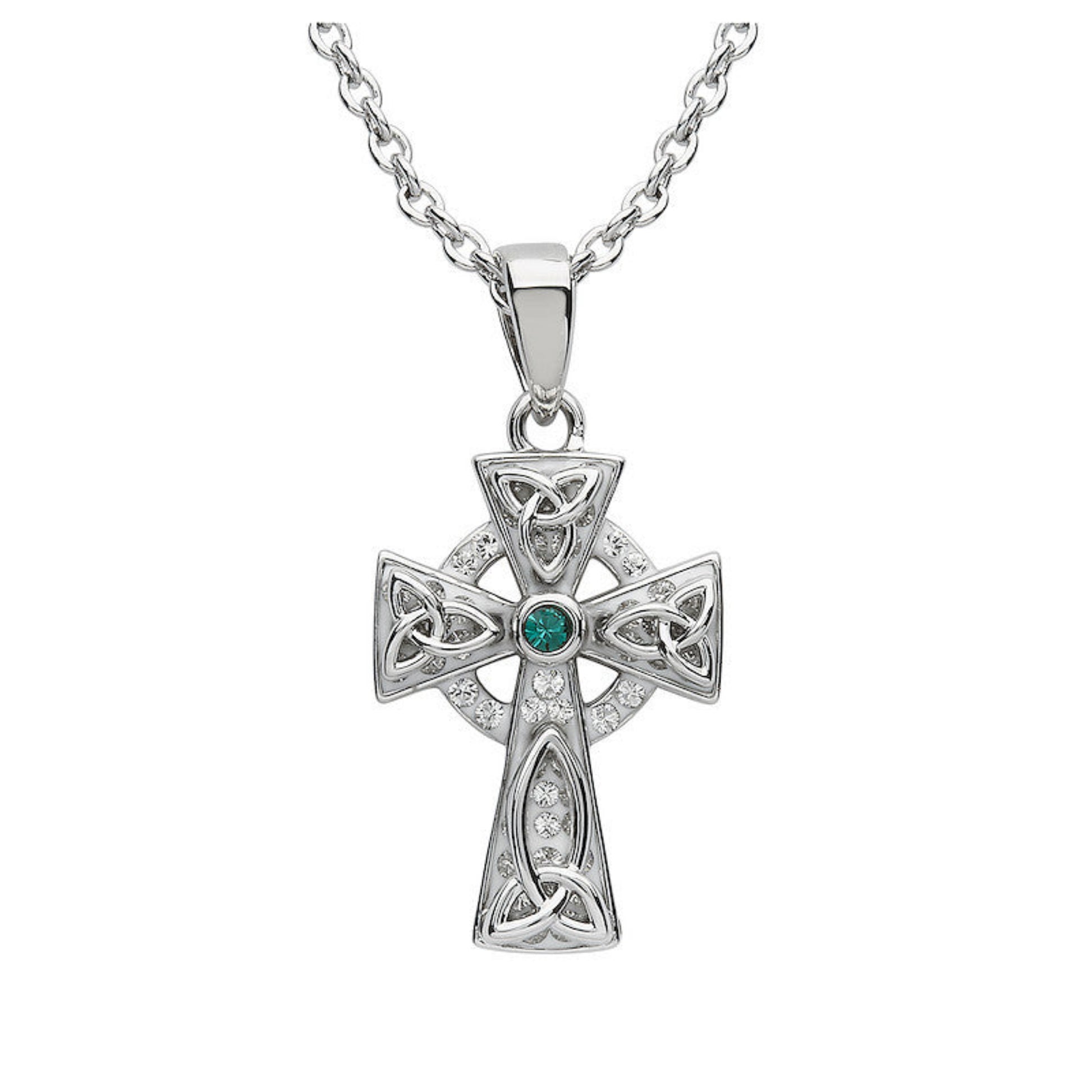 Silver cross pendant with emerald and diamonds on a white background