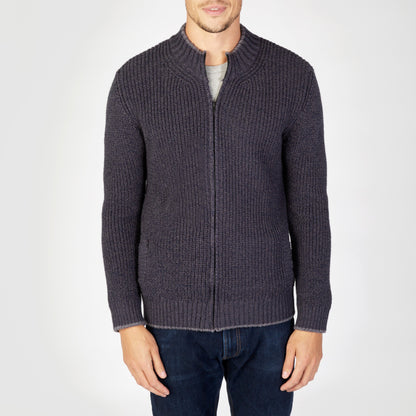 Man wearing a dark gray zip-up sweater and jeans on a white background