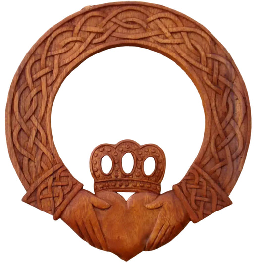 Wooden Claddagh symbol with intricate Celtic knot design on a stone background