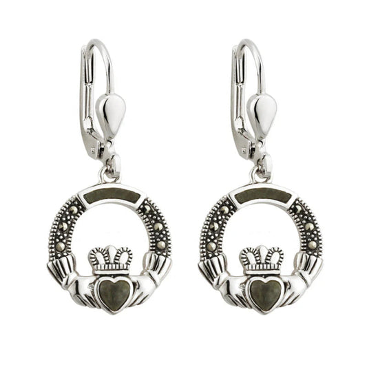 This image displays a pair of sophisticated silver drop earrings, featuring a captivating Claddagh design. Each earring consists of a beautifully crafted heart-shaped center, surrounded by intricate details and set within a classic Claddagh ring design.