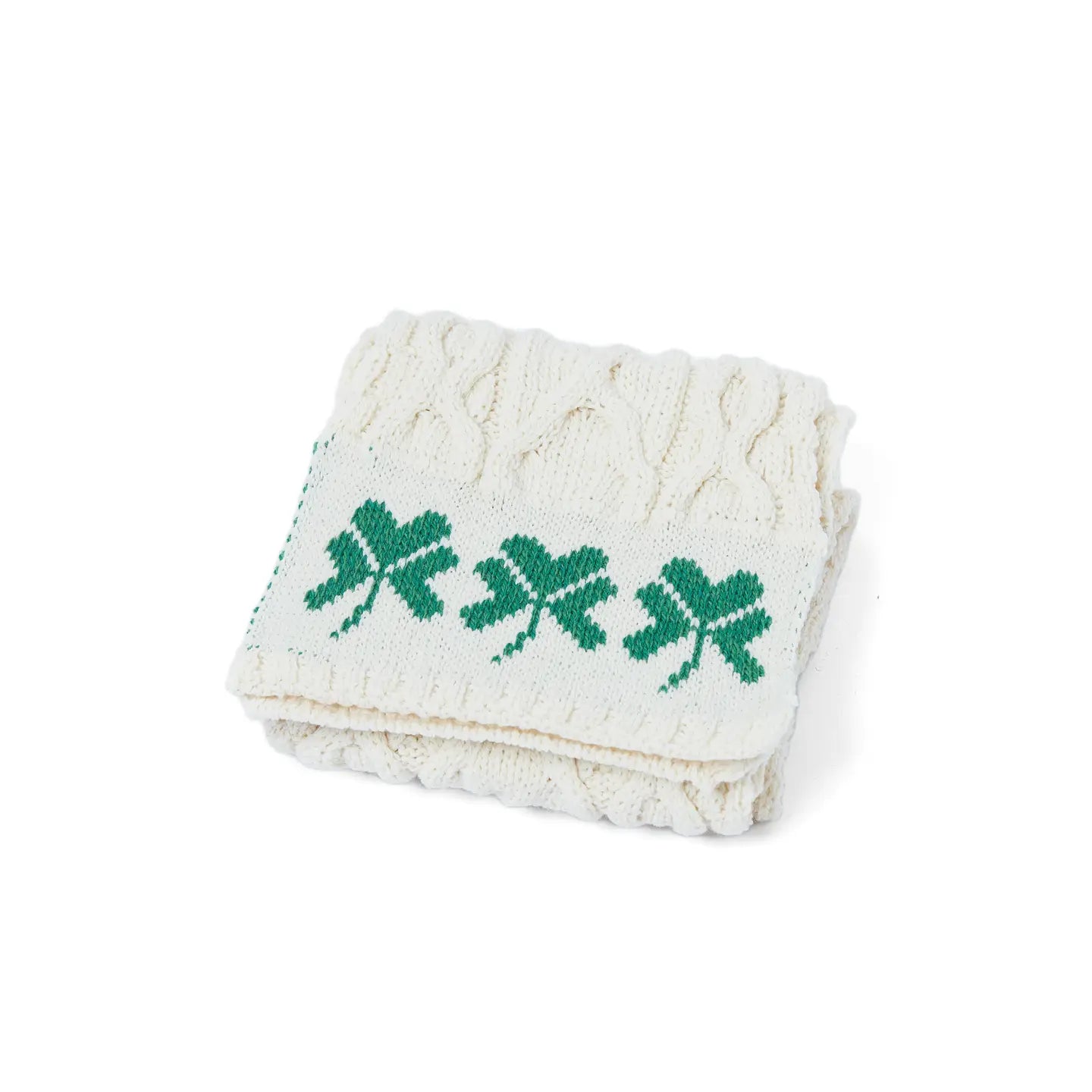 Folded towel with green leaf patterns on a white background