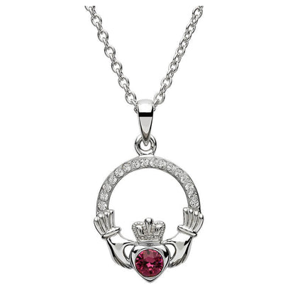 Silver claddagh pendant encrusted with white gems. The heart in the center contains one larger pink gem. 