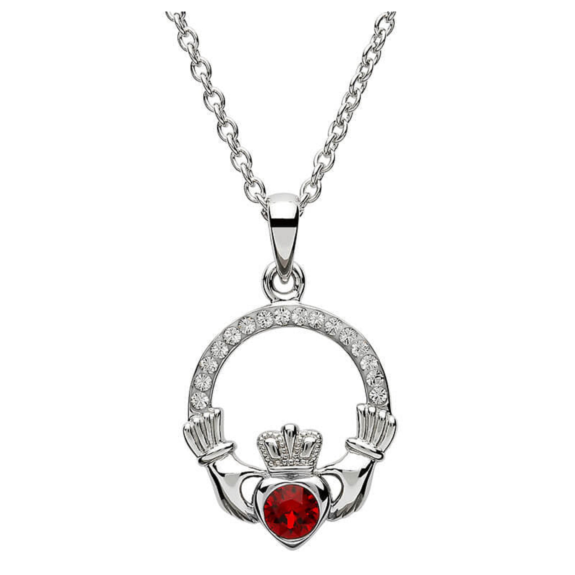 Silver claddagh pendant encrusted with white gems. The heart in the center contains one larger red gem. 