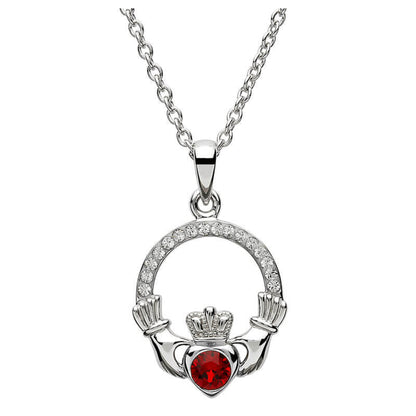 Silver claddagh pendant encrusted with white gems. The heart in the center contains one larger red gem. 