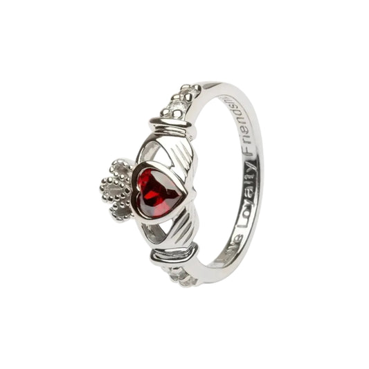 A sterling silver claddagh ring with a red heart-shaped gem in the center.