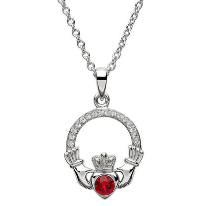 Silver claddagh pendant encrusted with white gems. The heart in the center contains one larger red gem. 