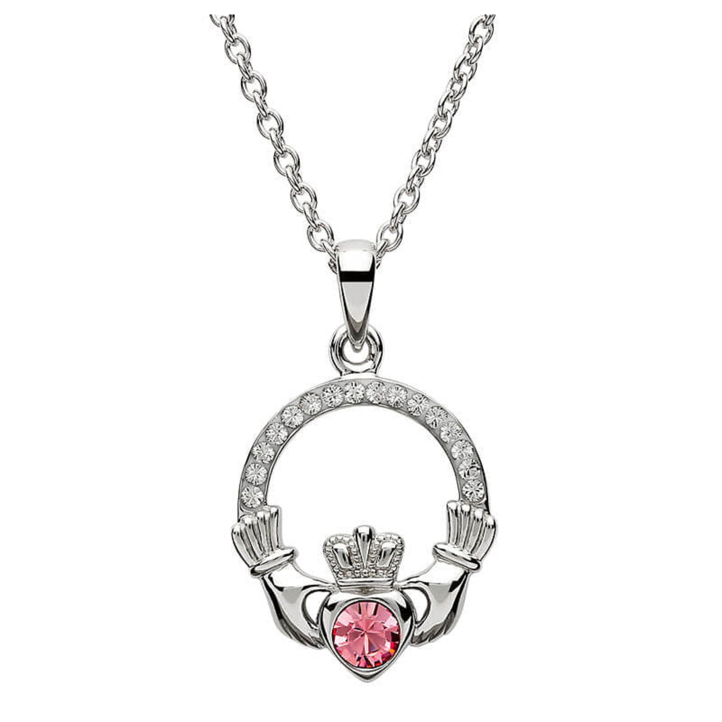Silver claddagh pendant encrusted with white gems. The heart in the center contains one larger pink gem. 