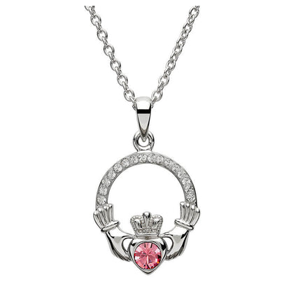 Silver claddagh pendant encrusted with white gems. The heart in the center contains one larger pink gem. 