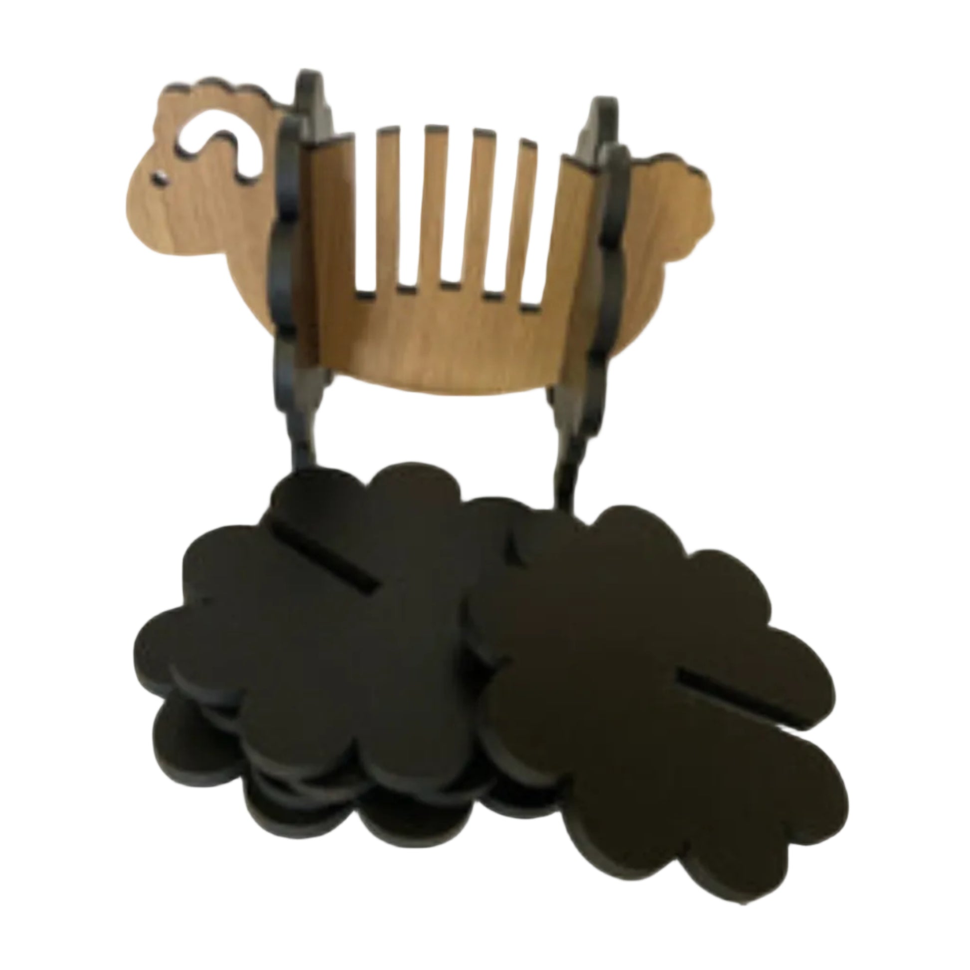 Wooden sheep-shaped holder with black cloverleafs on a white background