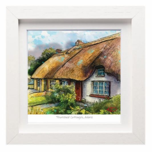Framed artwork of a thatched cottage with a white border