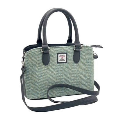Green textured handbag with black straps on a white background