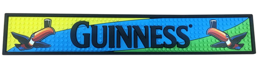 Guinness bar mat with toucan designs on a blue and green background