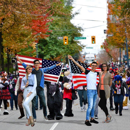 Two couples holding large American flags at a parade.