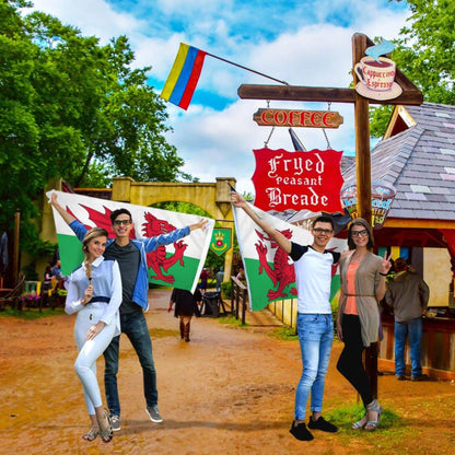 Two couples outdoors holding Welsh flags. 