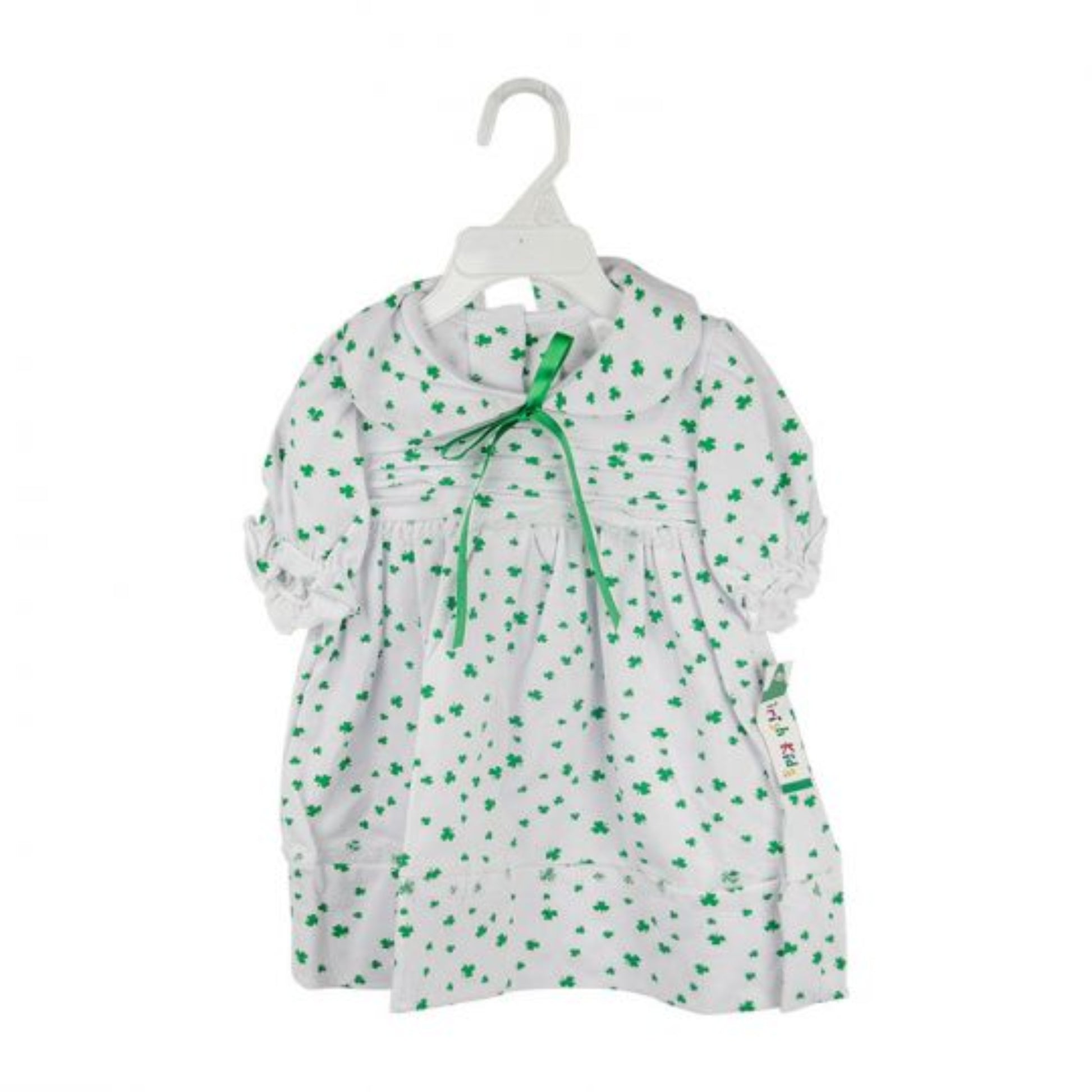 White dress with green floral pattern on a hanger against a white background