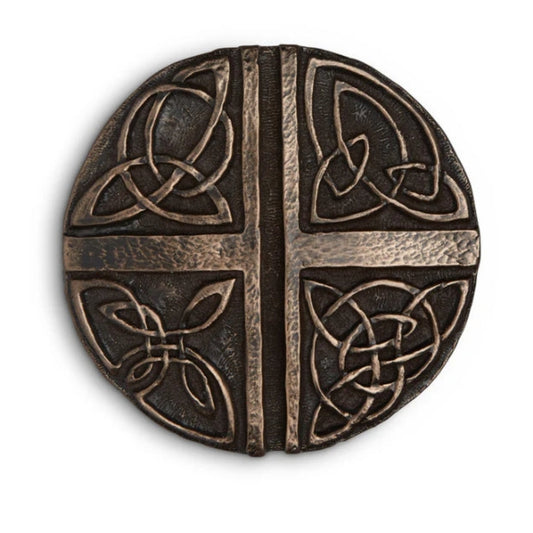 A round bronze decoration with a vertical and horizontal line. Each of the four corners has a different piece of Celtic knotwork. 