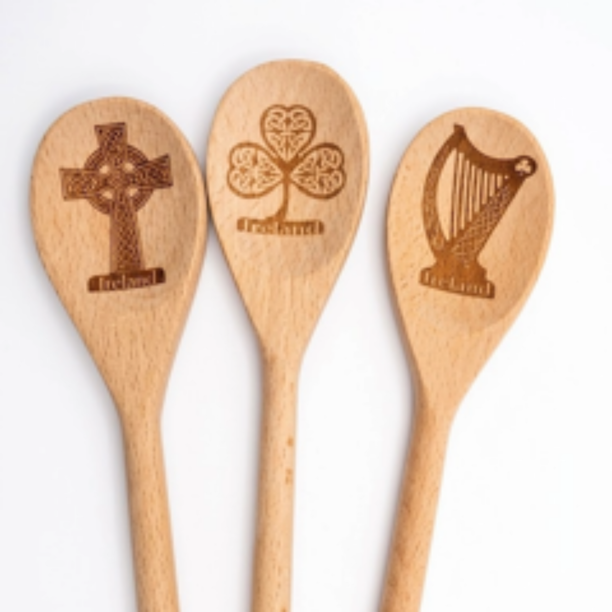 Three wooden spoons with Celtic designs on a white background