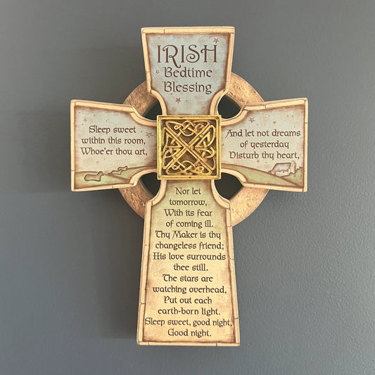 Decorative cross with 'Irish Bedtime Blessing' text on a gray wall.