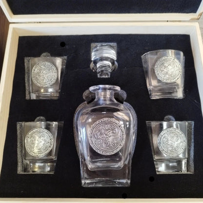 An elegant Mullingar Pewter decanter set displayed in a distressed wood-effect box, including a crystal decanter and four matching glasses, all adorned with pewter designs.