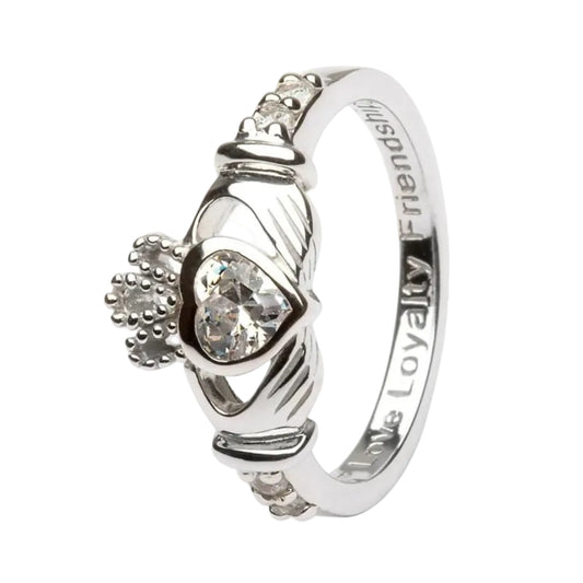 A sterling silver Claddagh ring with a red gemstone centerpiece and intricate details.