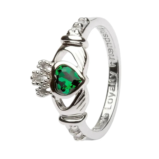 A sterling silver Claddagh ring with a red gemstone centerpiece and intricate details.