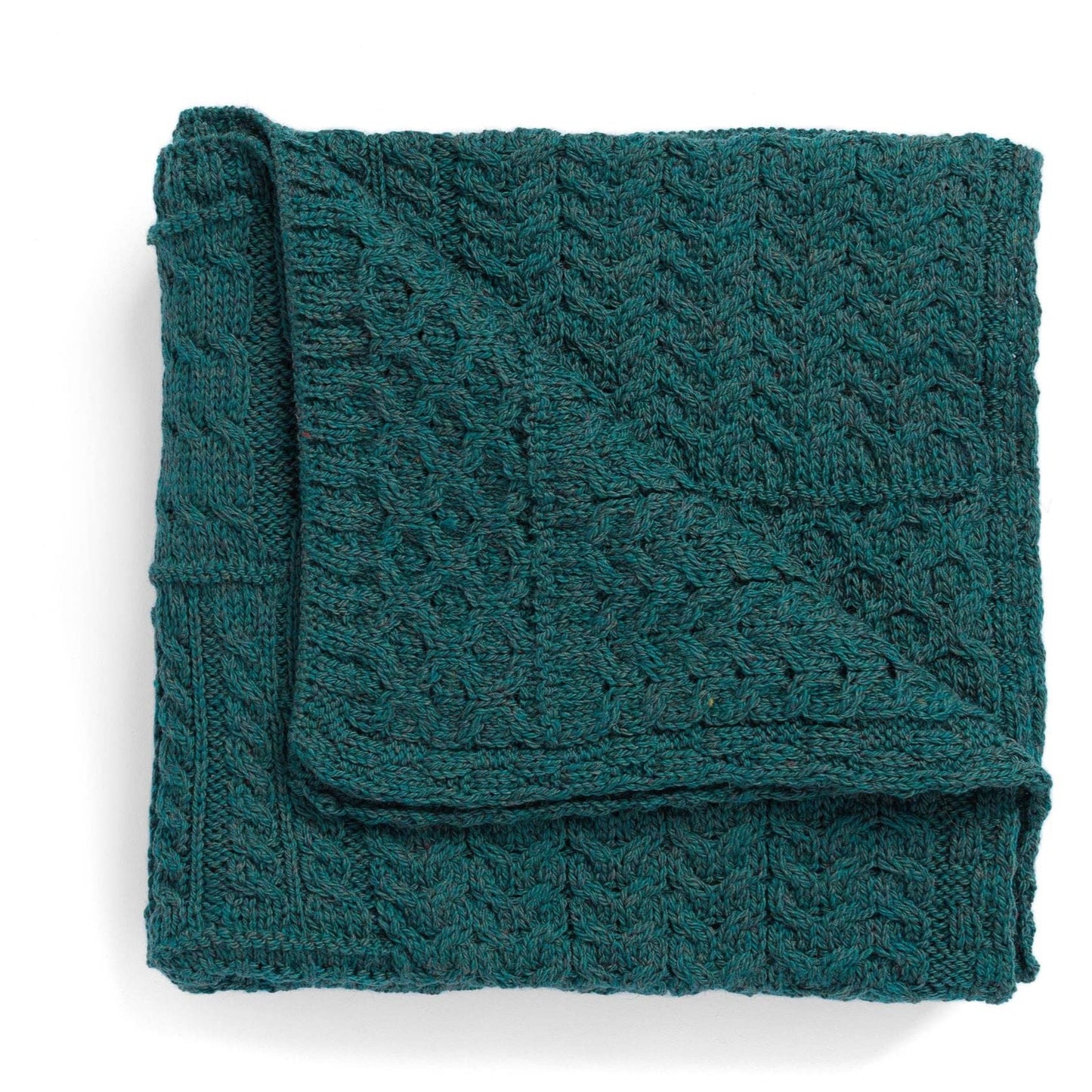 Folded teal knitted blanket on a white background