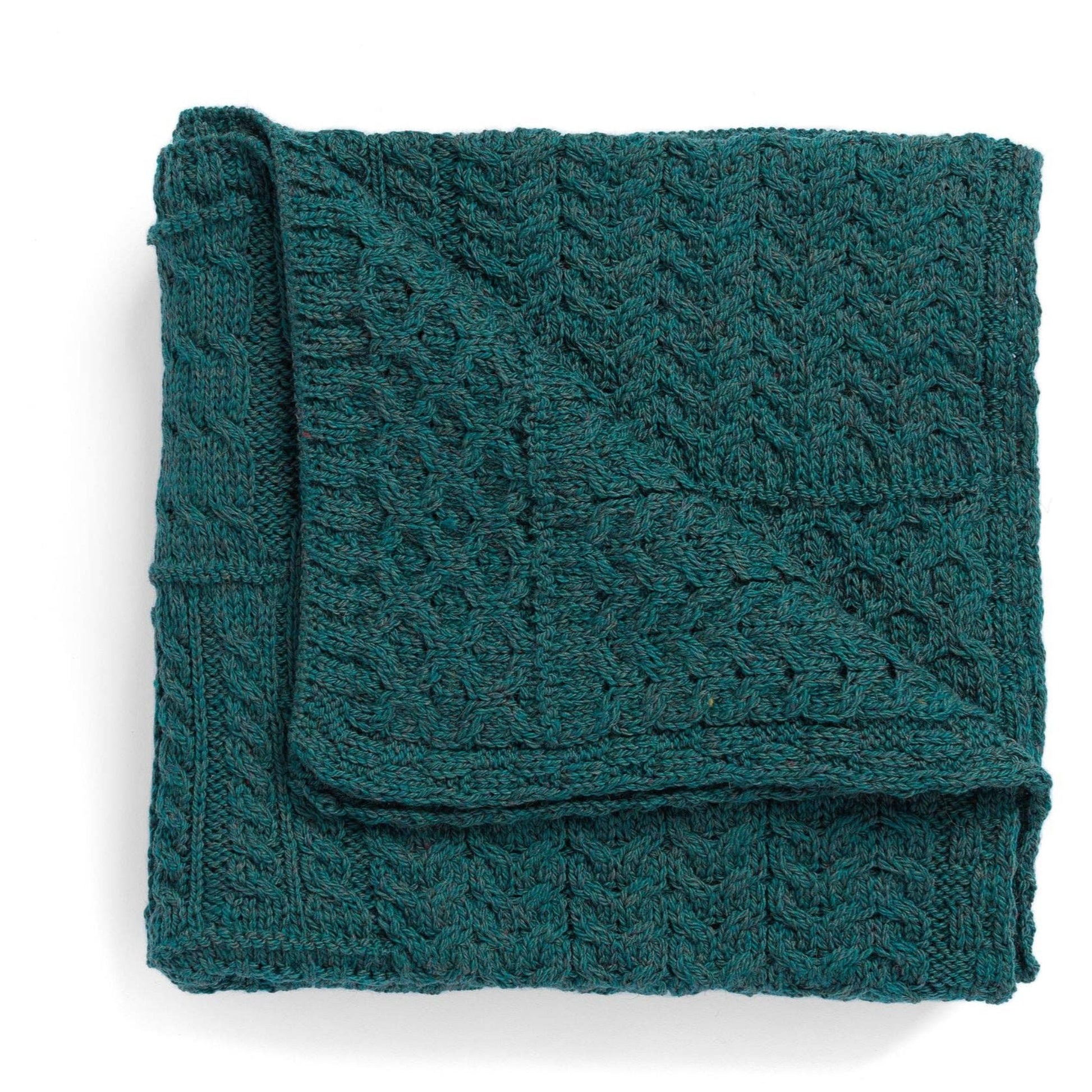 Folded teal knitted blanket on a white background