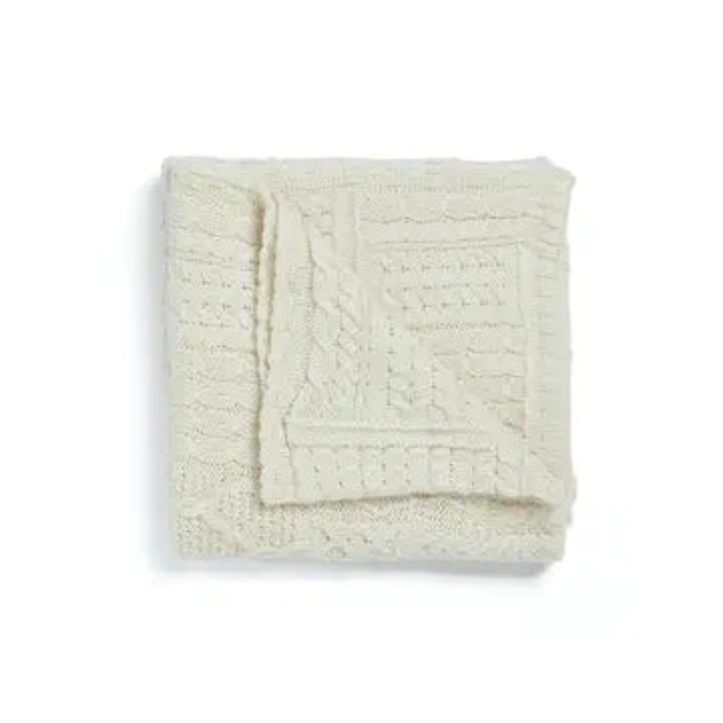 Folded cream-colored textured blanket on a white background