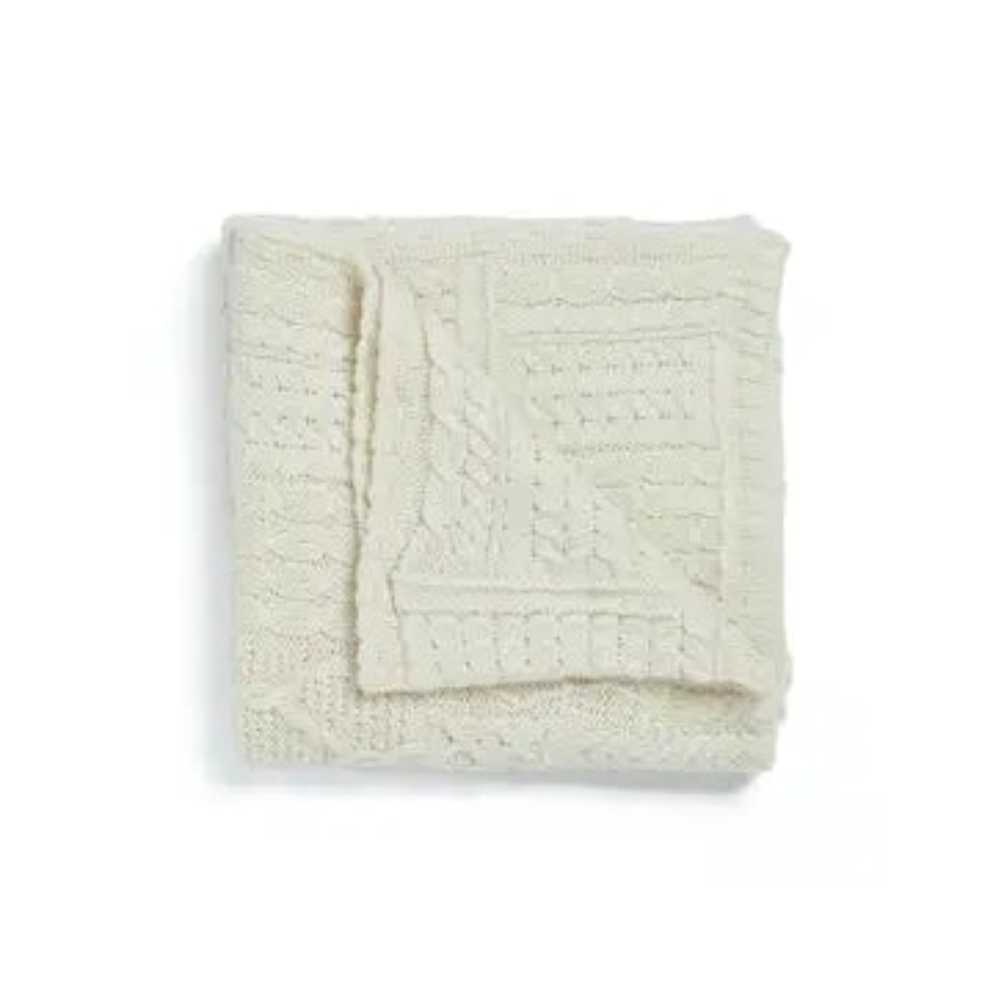 Folded cream-colored textured blanket on a white background