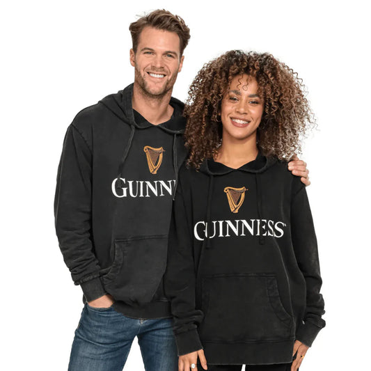 Two people wearing black Guinness hoodies with the brand logo.