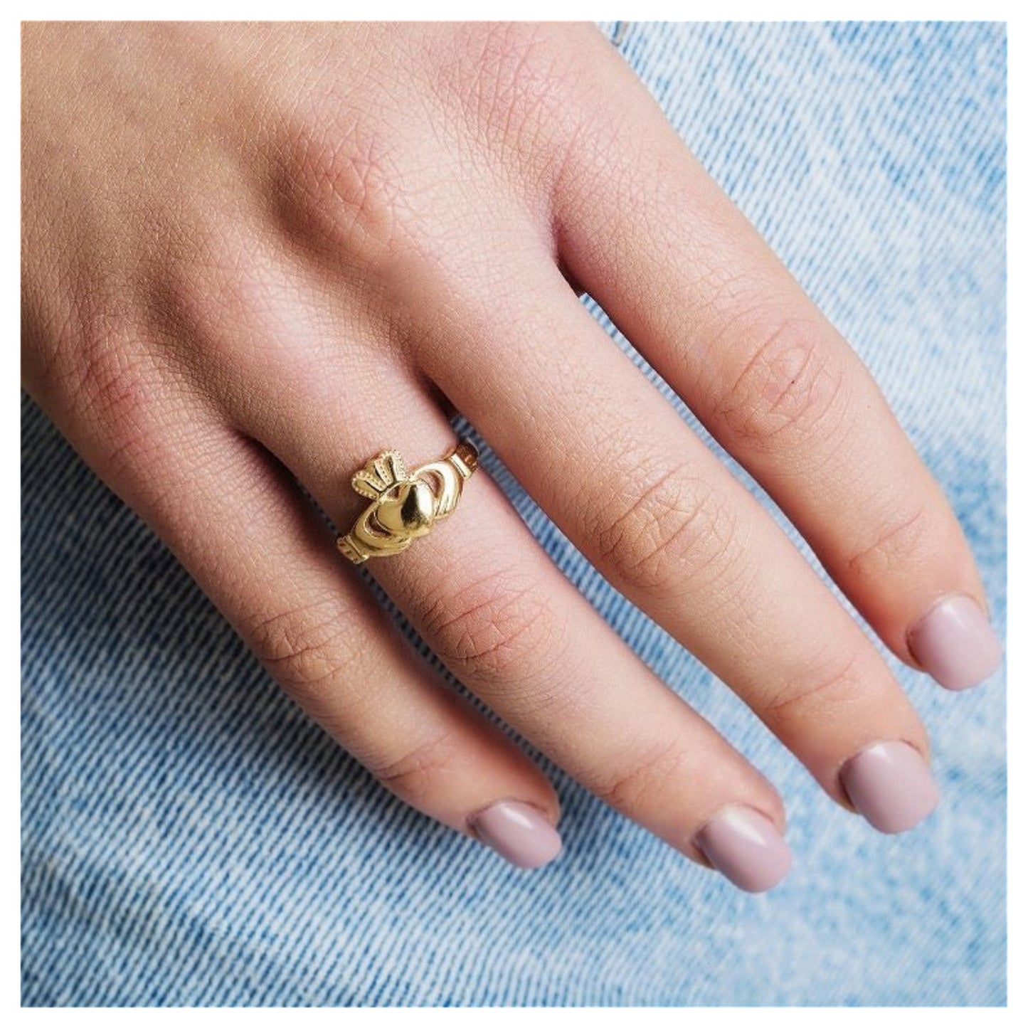 Close-up of a woman's hand wearing the gold claddagh ring.