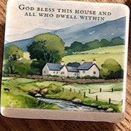 Decorative coaster with a scenic illustration and text on a wooden surface