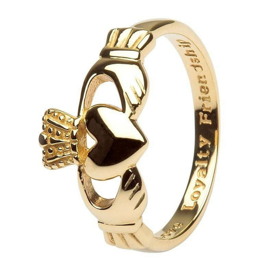 Gold claddagh ring on a white background.