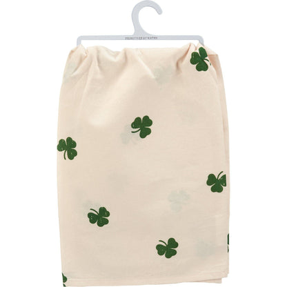 Beige towel with green shamrock patterns on a white background