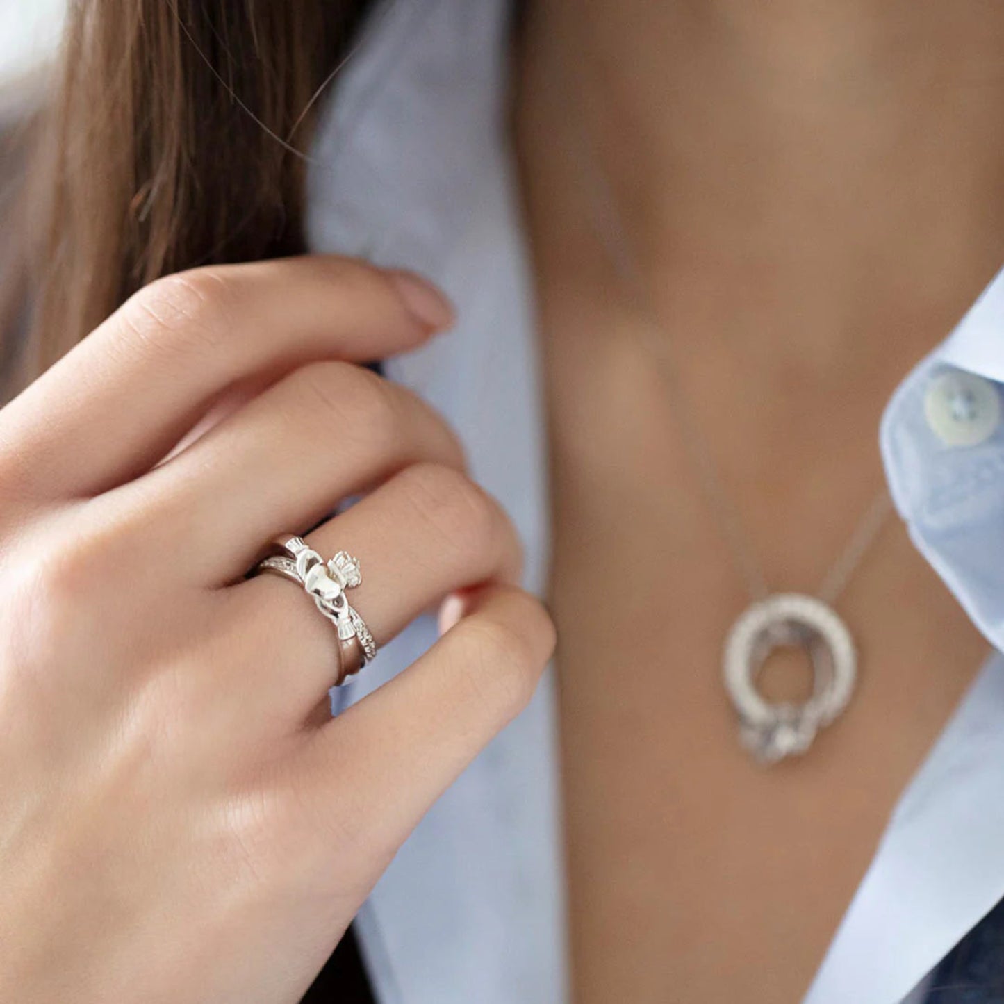 Close-up of a hand wearing a silver ring with a blurred background