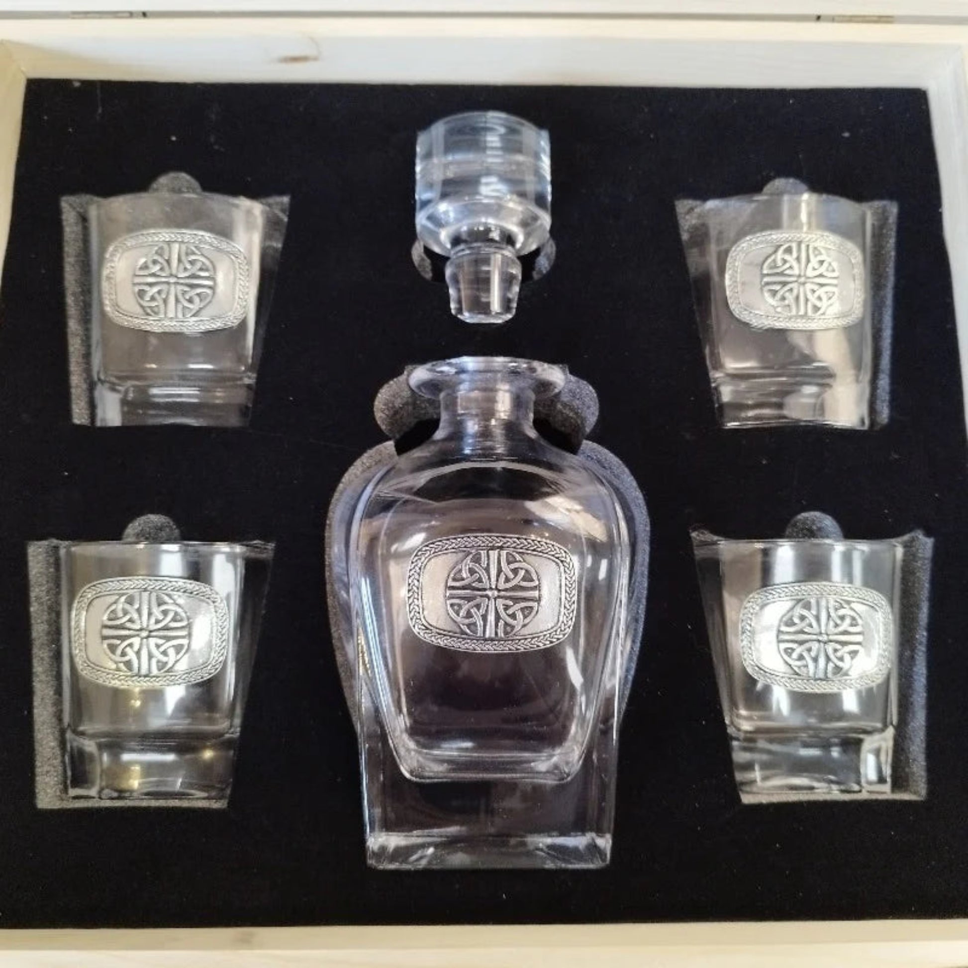 An elegant Mullingar Pewter decanter set displayed in a distressed wood-effect box, including a crystal decanter and four matching glasses, all adorned with pewter designs.