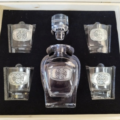 An elegant Mullingar Pewter decanter set displayed in a distressed wood-effect box, including a crystal decanter and four matching glasses, all adorned with pewter designs.